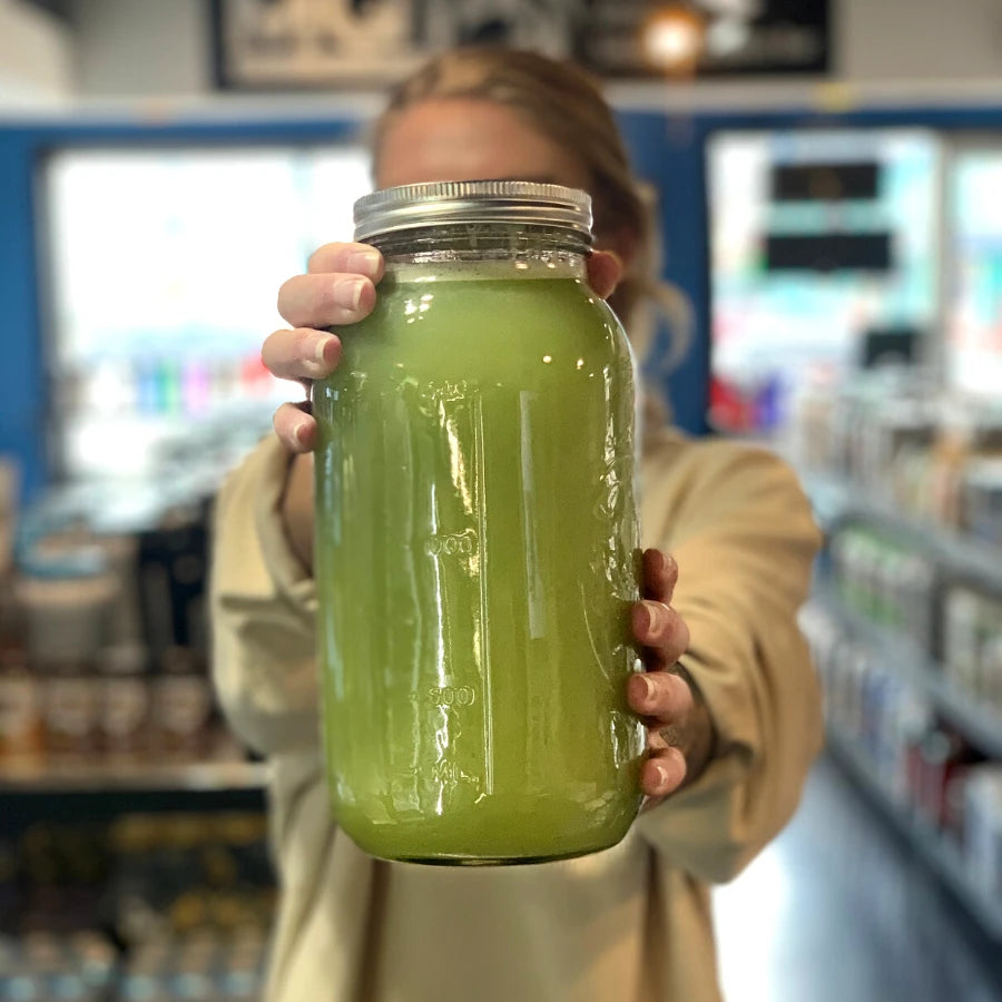 Person holding a jar of green juice