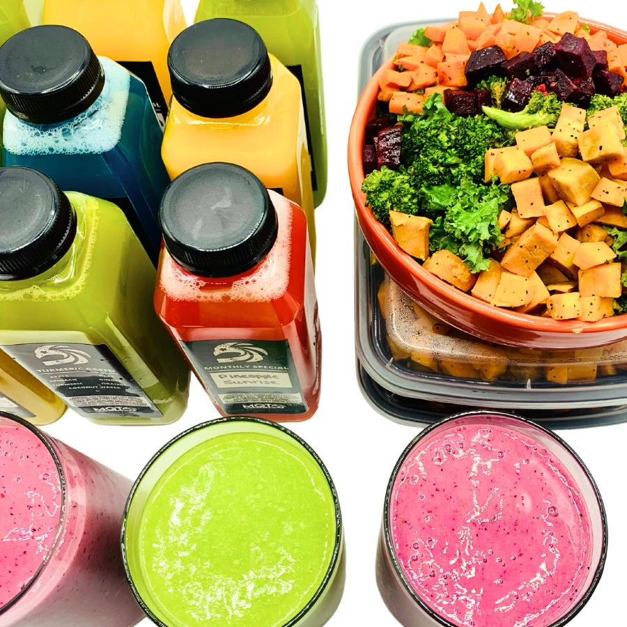 Assorted smoothies in cups with a container of salad on a white background