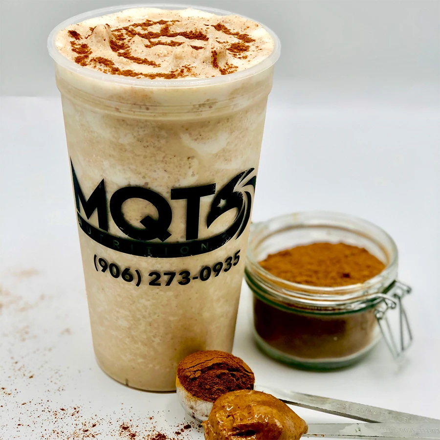 Smoothie  in a cup with a jar of cinnamon and cookies
