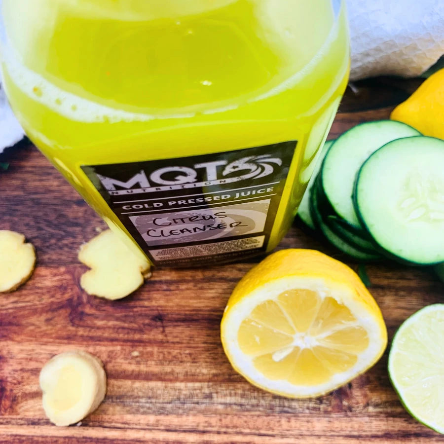 Citrus Cleanser bottle with lemons and cucumbers on a wooden surface