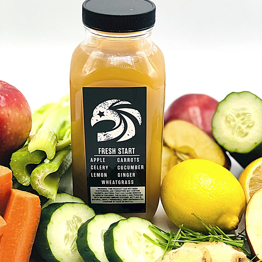 Bottle of 'Fresh Start' juice surrounded by fresh vegetables and fruits