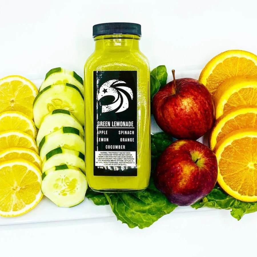 Green lemonade bottle surrounded by sliced fruits
