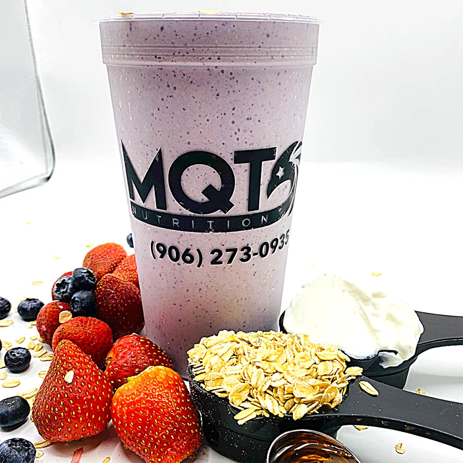Protein shake with berries, oats, and a spoon.