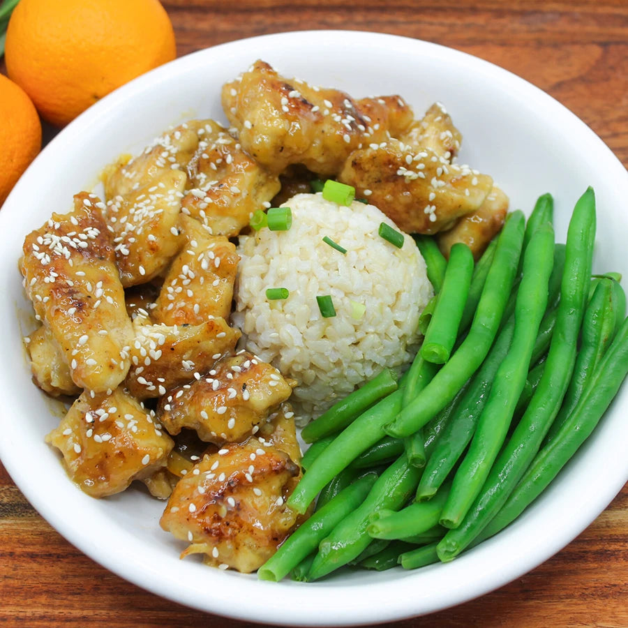 Bowl of orange chicken with rice and green beans.