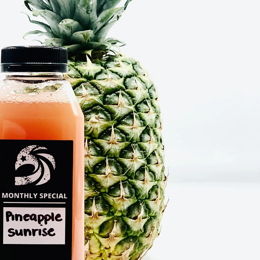 Pineapple juice bottle next to a whole pineapple
