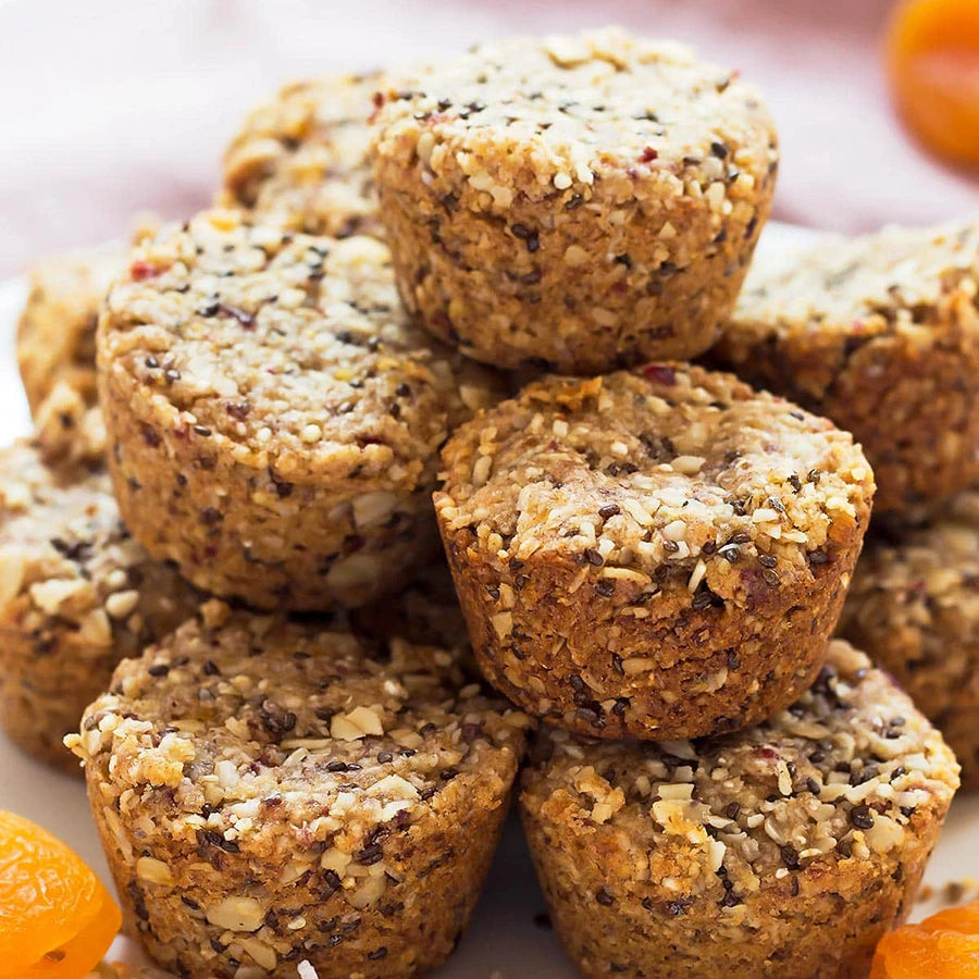 Stack of small granola bites with dried apricots on a white plate