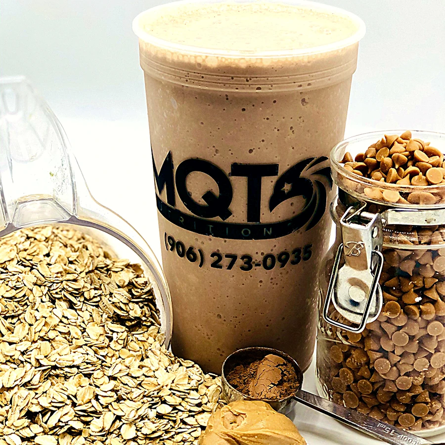 Chocolate shake in a cup with oats, peanut butter, and chocolate chips