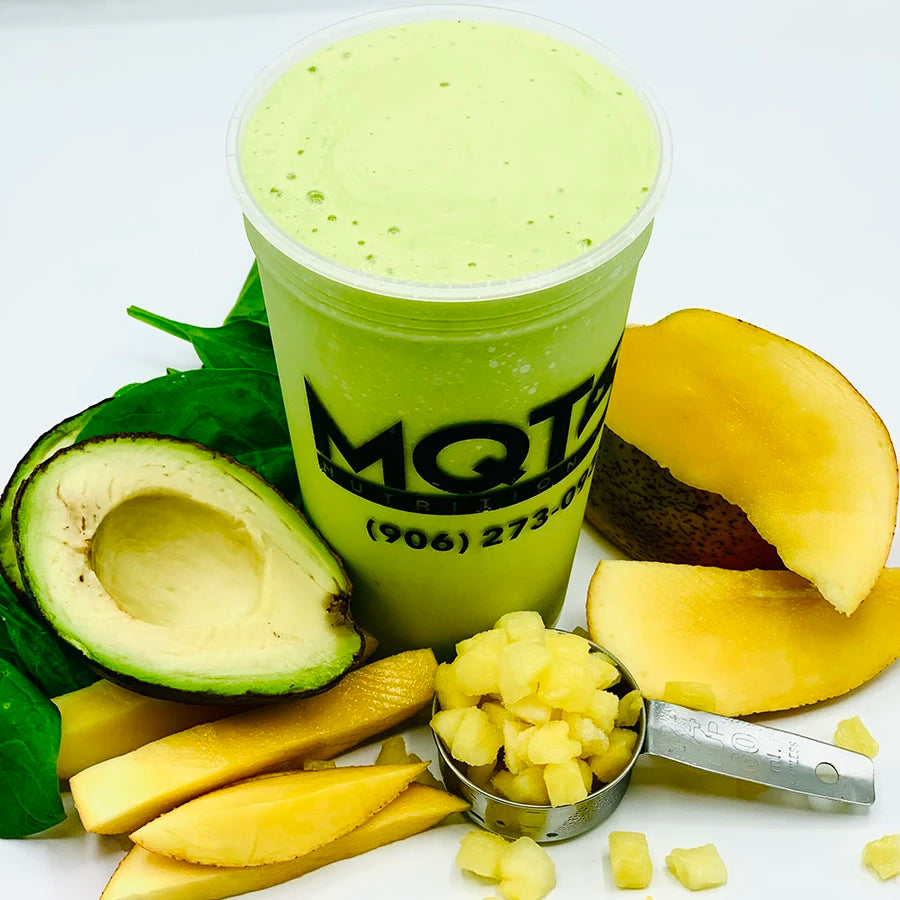 Green smoothie in a cup with avocado, mango, and pineapple