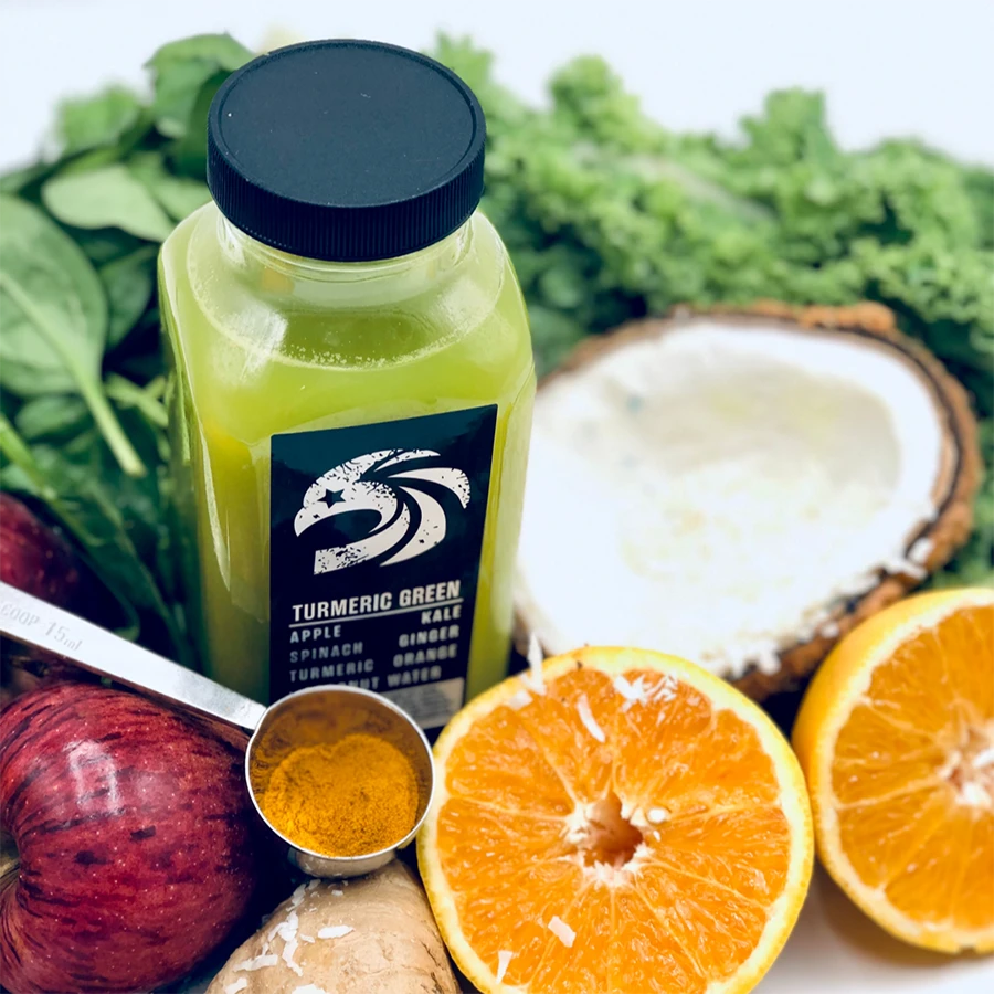 Bottle of Turmeric Green juice with ingredients like oranges, turmeric, and a coconut.